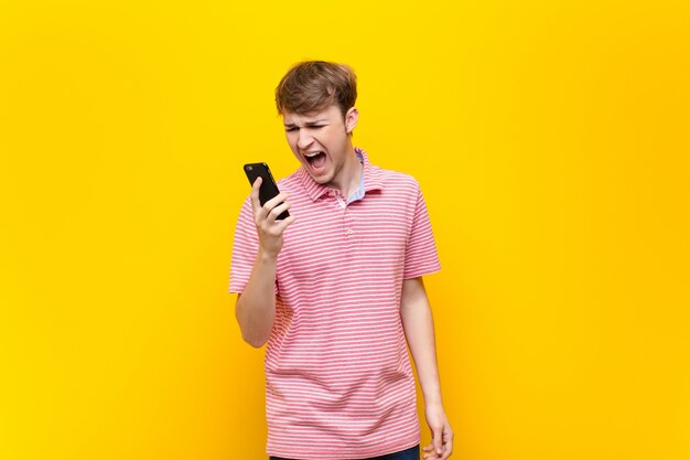 Junger blonder Mann mit einem Smartphone-Handy