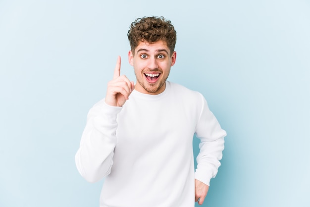 Junger blonder Mann mit lockigem Haar, der eine Idee hat