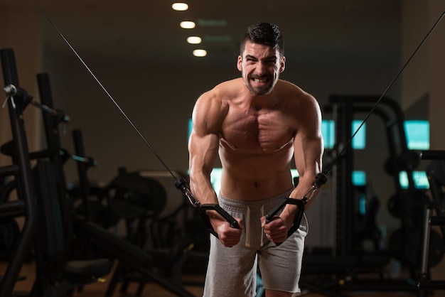 Junger Bodybuilder arbeitet an seiner Brust mit Kabel-Frequenzweiche im Fitnessstudio