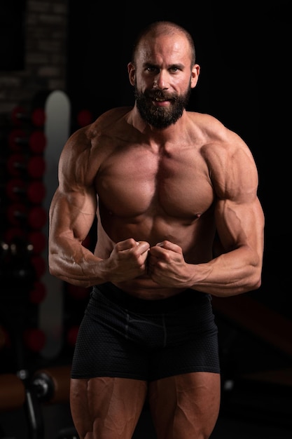 Junger Bodybuilder, der Muskeln biegt