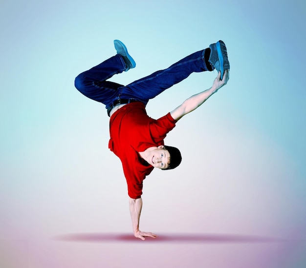 Junger Breakdancer-Typ steht auf der einen Seite und tanzt und posiert