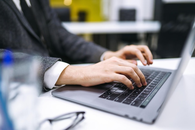 Junger Büroleiter, der im Büro mit Papieren und Computern arbeitet, überprüft und analysiert Dokumente