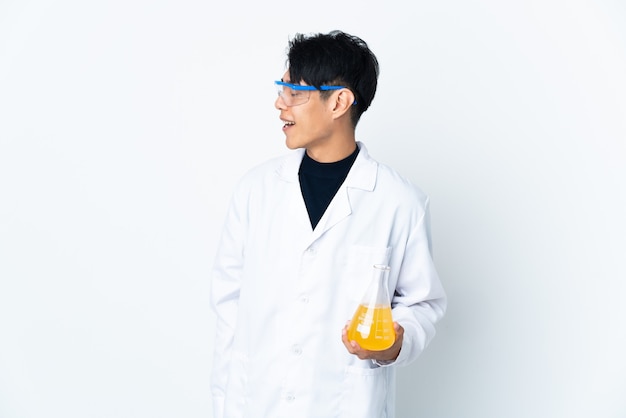 Junger chinesischer wissenschaftlicher Mann lokalisiert auf weißer Wand, die in seitlicher Position lacht