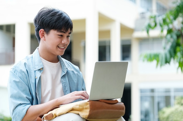 Junger Collage-Student, der Computer und mobiles Gerät verwendet, um online zu studieren. Bildung und Online-Lernen.