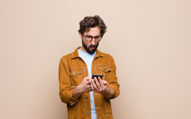 Junger cooler Mann, der sein Smartphone benutzt