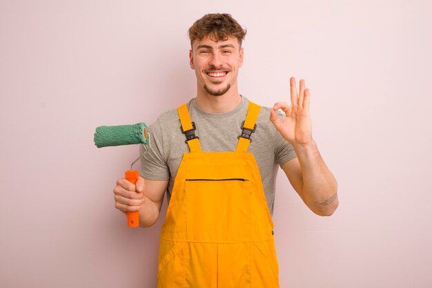 Junger cooler mann, der sich glücklich fühlt, die zustimmung mit dem heimwerkerkonzept der okaygeste zu zeigen