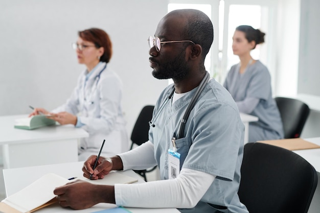 Junger Doktor, der am Seminar sitzt