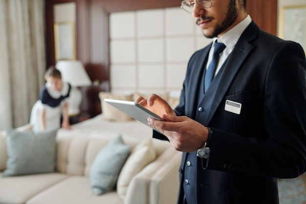 Junger eleganter Manager eines luxuriösen Hotels mit Tablet