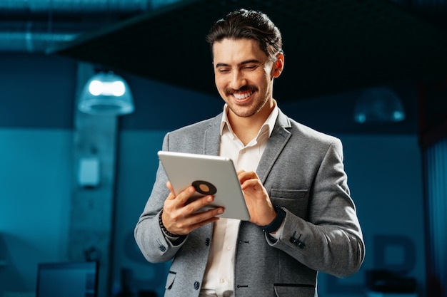 Junger erfolgreicher Geschäftsmann arbeitet im Büro an einem digitalen Tablet