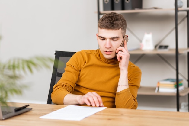 Junger erfolgreicher Mann, der mit Dokumenten im Büro arbeitet