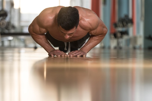 Junger erwachsener Athlet, der Push-ups als Teil des Bodybuilding-Trainings macht