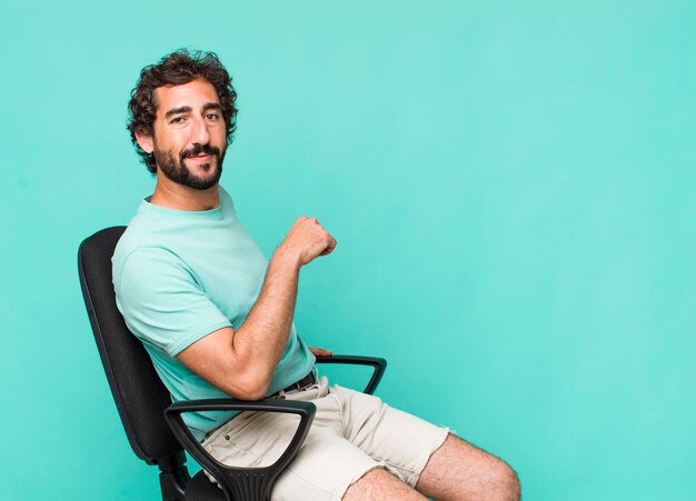 Junger erwachsener hispanischer Verrückter, der auf einem Stuhl sitzt