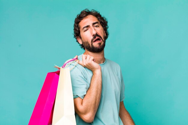 Junger erwachsener hispanischer verrückter Mann Einkaufstaschen Konzept