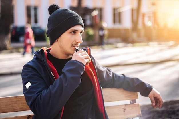 Junger erwachsener Mann raucht Tabakgerät elektronische Zigarettenheizung