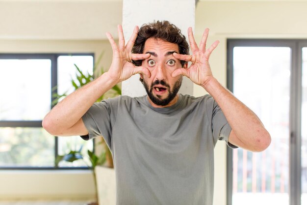 Foto junger erwachsener verrückter mit ausdrucksstarker pose in einem modernen hausinneren