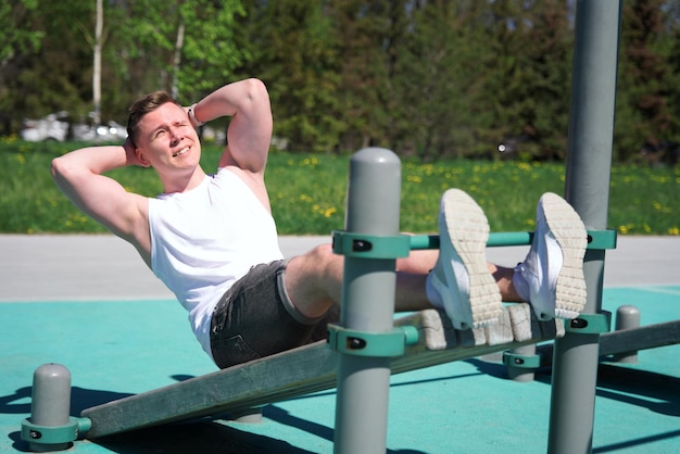 Junger, fitter, starker Mann trainiert im Freien Fitness und gesundes Lebensstilkonzept