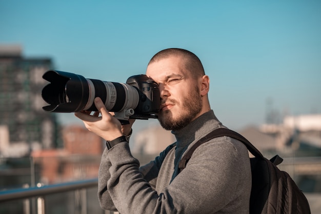 Junger Fotograf mit Kamera, die Bilder macht