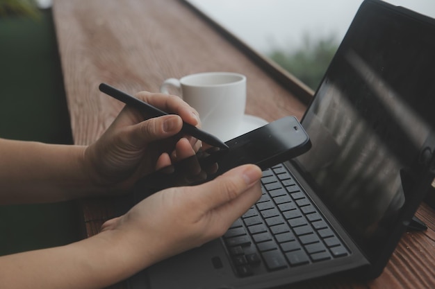 Foto junger freiberuflicher reisender mit hut, der überall online mit laptop arbeitet und die aussicht auf die berge genießt