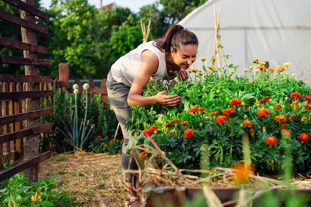 Junger Gärtner im Garten, der Blume riecht