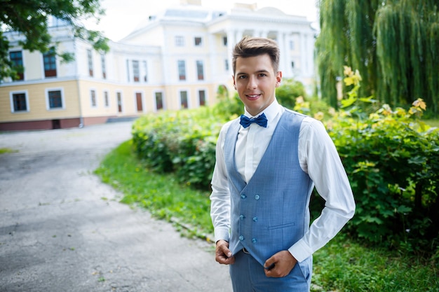 Junger Geschäftsmann Bräutigam an ihrem Hochzeitstag, stilvolle Kleidung, ein Spaziergang im Park