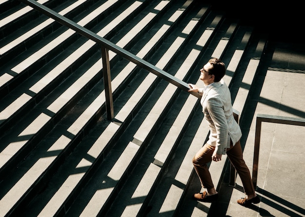 Junger Geschäftsmann, der die Treppe hinaufgeht