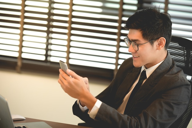 Foto junger geschäftsmann, der e-mail am intelligenten telefon liest