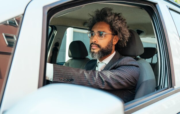 Junger Geschäftsmann, der sein Auto fährt