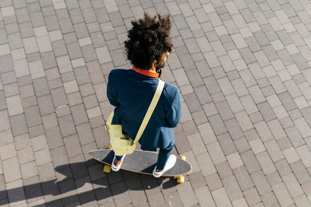 Junger Geschäftsmann, der Skateboard auf einem Platz fährt