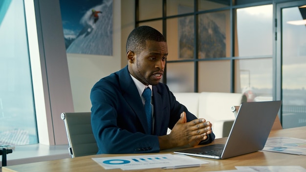 Junger Geschäftsmann in einem Anzug, der auf einem Laptop schreibt Junger Geschäftsmann im Büro