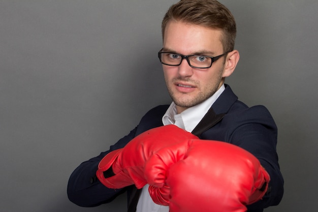 Junger Geschäftsmann mit Boxhandschuhen