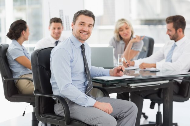 Junger Geschäftsmann mit den Kollegen, die im Büro sich besprechen