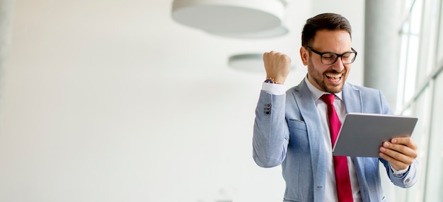 Junger Geschäftsmann mit digitaler Tablette im Büro