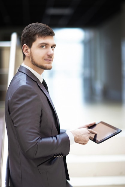 Junger Geschäftsmann mit einem Tablet-PC