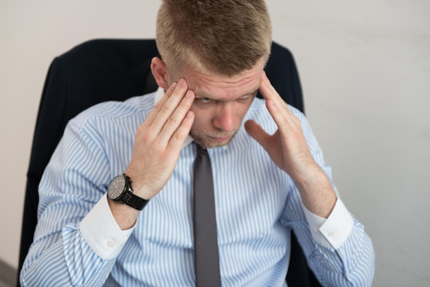 Junger Geschäftsmann mit Problemen und Stress im Büro