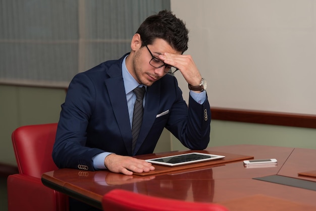 Junger Geschäftsmann mit Problemen und Stress im Büro