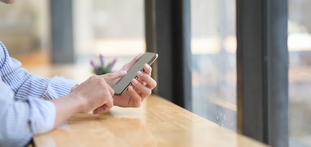 junger Geschäftsmann mit seinem Smartphone im modernen Büro