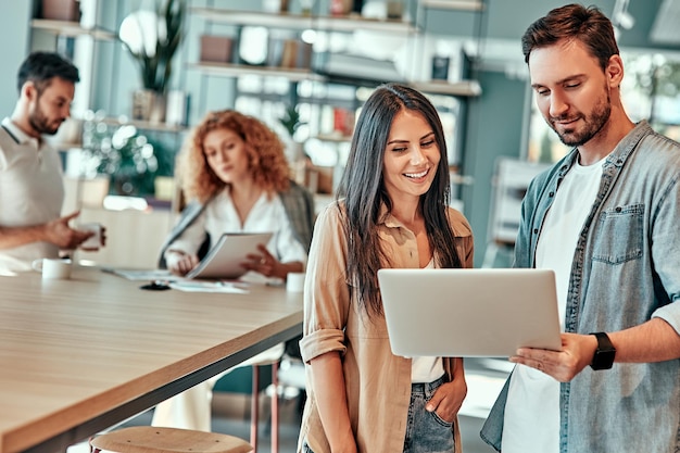 Junger Geschäftsmann und Geschäftsfrau Blick auf Laptop-Bildschirm im Büro Business Team arbeitet am Hintergrund