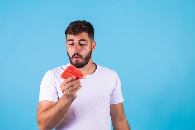 Junger gesunder hübscher Junge, der Wassermelone isst