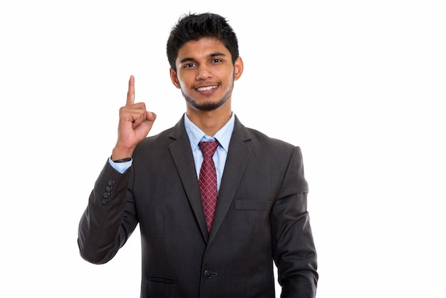 junger glücklicher indischer Geschäftsmann, der lächelt, während Finger oben zeigt