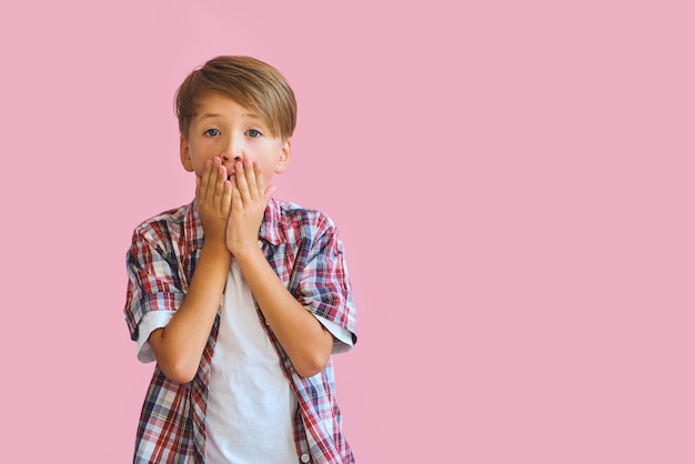 Junger glücklicher jugendlich Junge mit in den beiläufigen auf rosa Hintergrund