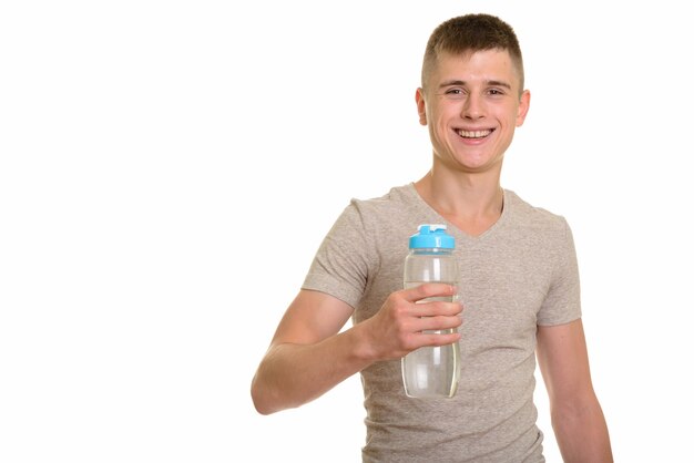 Junger glücklicher kaukasischer Mann, der lächelt und Wasserflasche hält