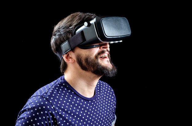 Junger glücklicher Mann, der virtuelle Realität erlebt