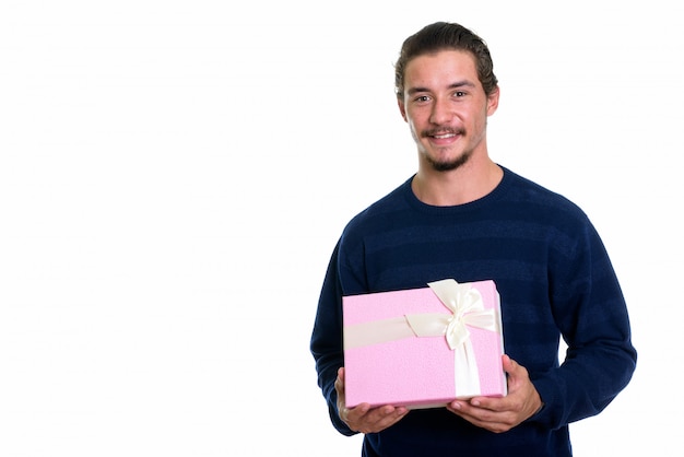 Junger glücklicher Mann lächelnd, während Geschenkbox halten
