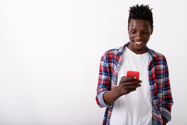 Junger glücklicher Mann lächelnd, während Handy benutzt