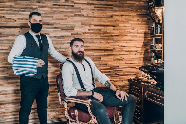 Junger, gut aussehender Hipster-Mann, der einen Friseursalon besucht. Trendiges und stylisches Bartstyling und -schnitt.