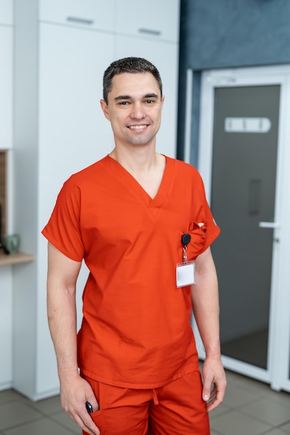 Junger gutaussehender Arzt in Uniform. Professioneller medizinischer Mitarbeiter im modernen Krankenhaus.