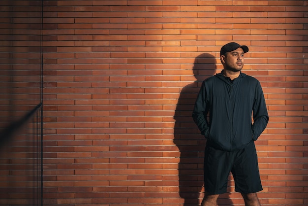 Junger gutaussehender asiatischer Mann, der Sportbekleidung trägt, die unter dem Gebäude in der Stadt läuft, die im Freien läuft Porträts eines indischen Mannes, der auf der Straße joggt Training Athlet Outdoor-Konzept