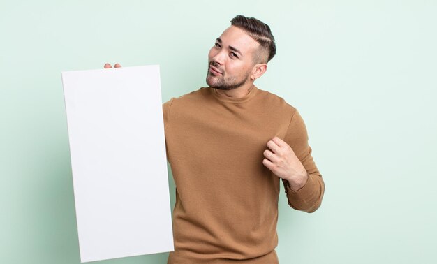 Junger gutaussehender Mann, der arrogant, erfolgreich, positiv und stolz aussieht. Konzept der leeren Leinwand