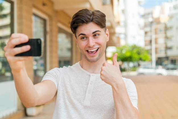 Foto junger gutaussehender mann, der ein selfie mit handy macht