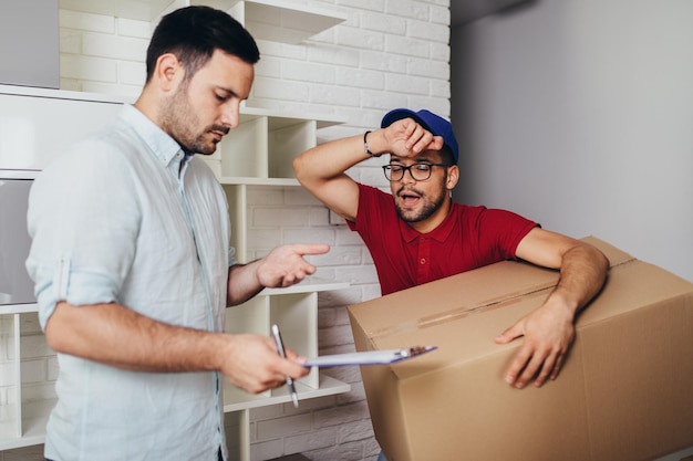 Foto junger gutaussehender mann, der in neue wohnung einzieht.